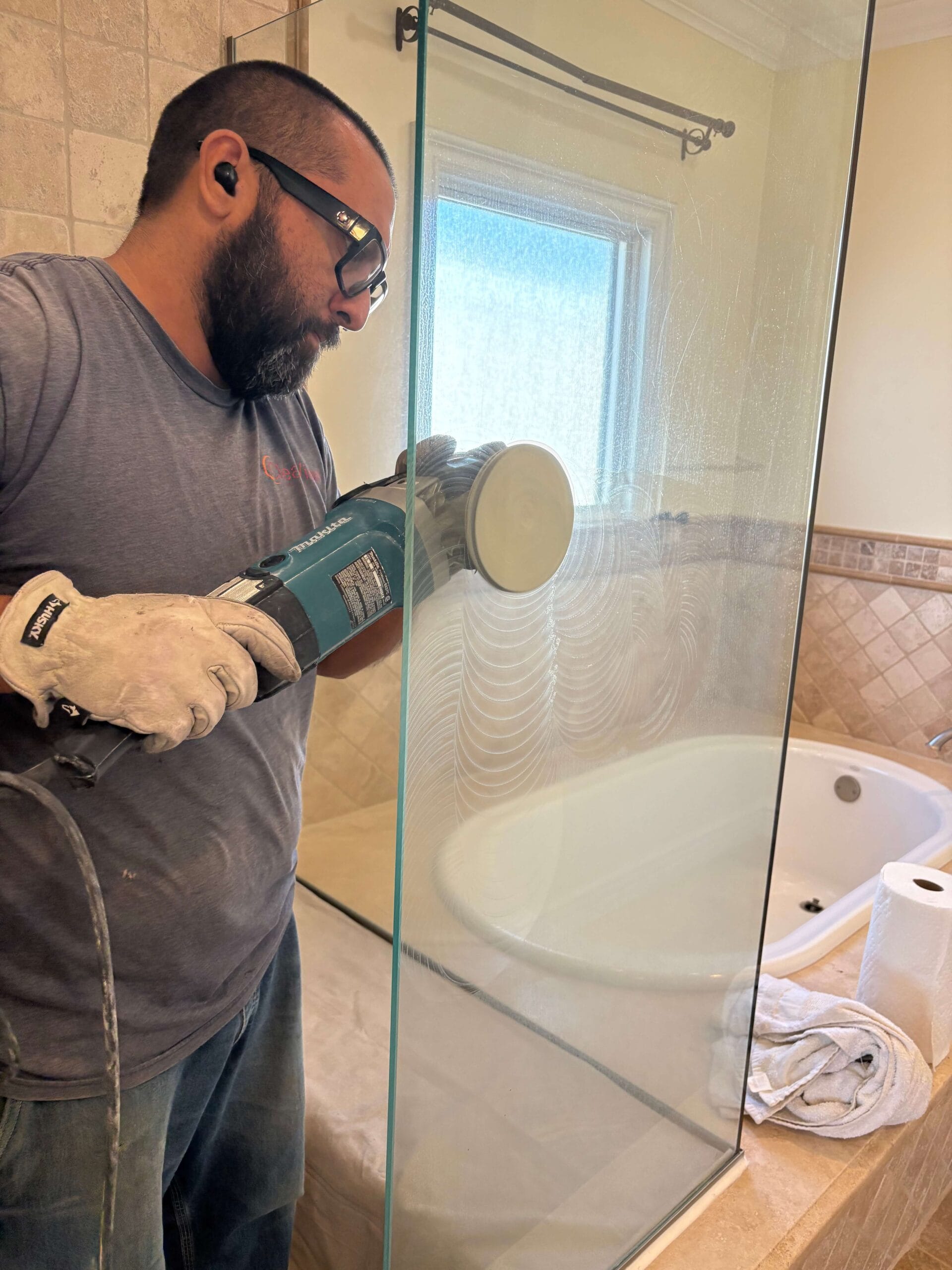 professional glass restoration technician polishing shower glass to remove mineral deposits Seal Beach