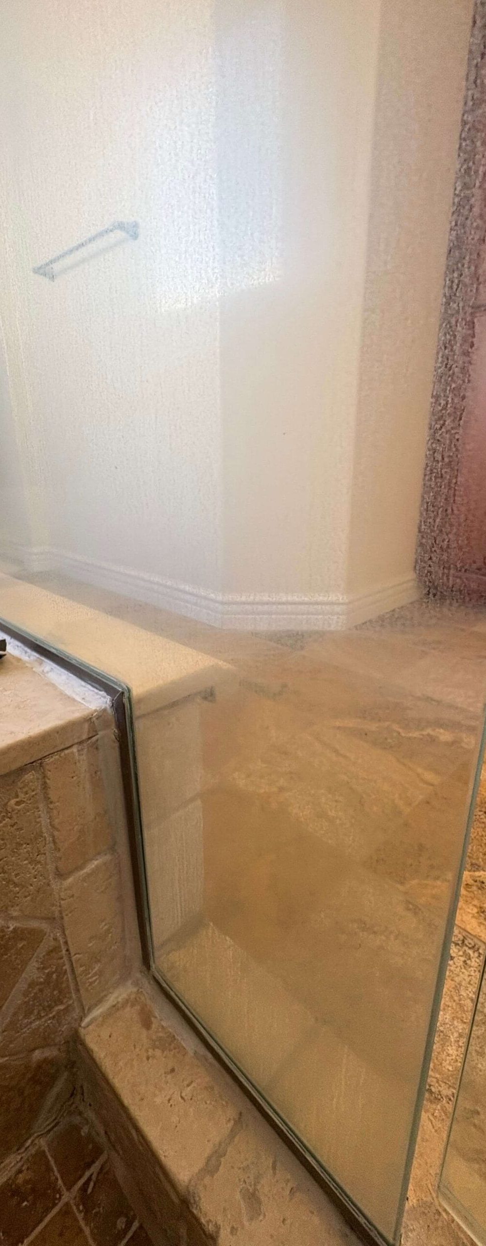 shower glass with severe hard water mineral deposits before restoration Seal Beach